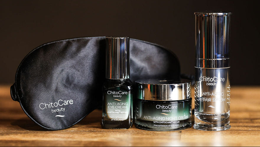 ChitoCare beauty products including a sleep mask, eye cream, night cream and serum on a wooden surface.